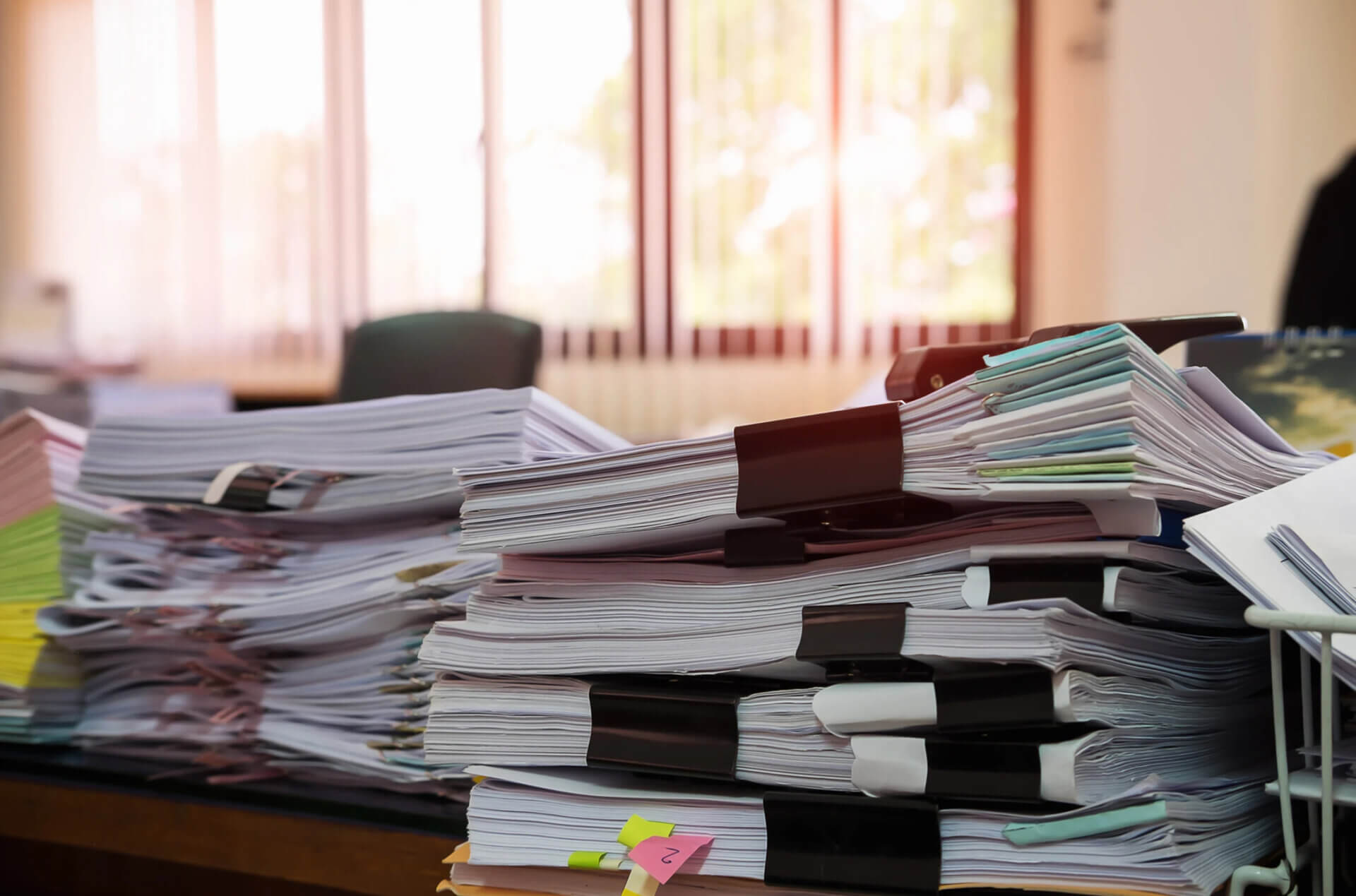 Lista obecności: pozbądź się papierowego bałaganu raz na zawsze 1 Stos papierowych list obecności na budowie – tradycyjna dokumentacja powodująca błędy i opóźnienia